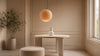 A white table featuring a lamp and a stool, creating a minimalist and functional workspace